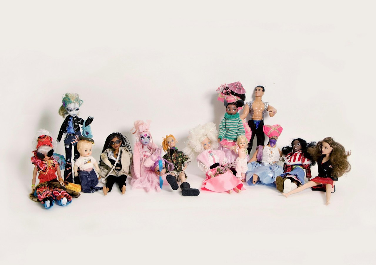 an assortment of dolls wearing handmade custom outfits and costumes
